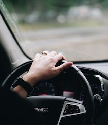 female hand on automobile steering wheel